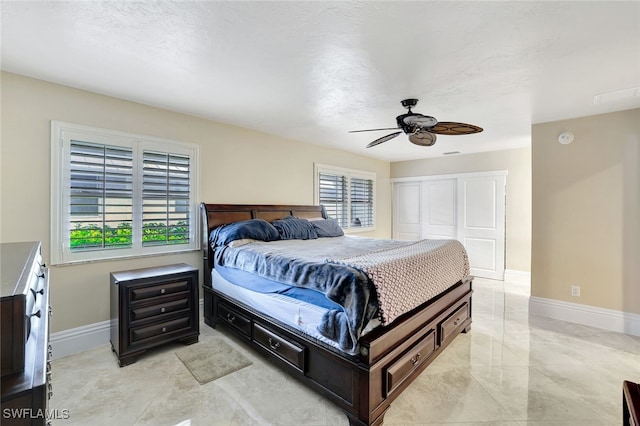 bedroom featuring ceiling fan, a textured ceiling, and a closet