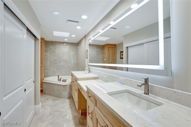 bathroom featuring tiled bath and vanity