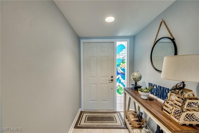 doorway to outside featuring light tile patterned floors and baseboards