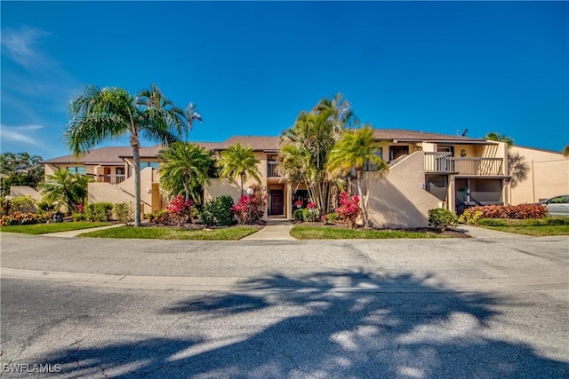 view of front of home with a balcony and stucco siding