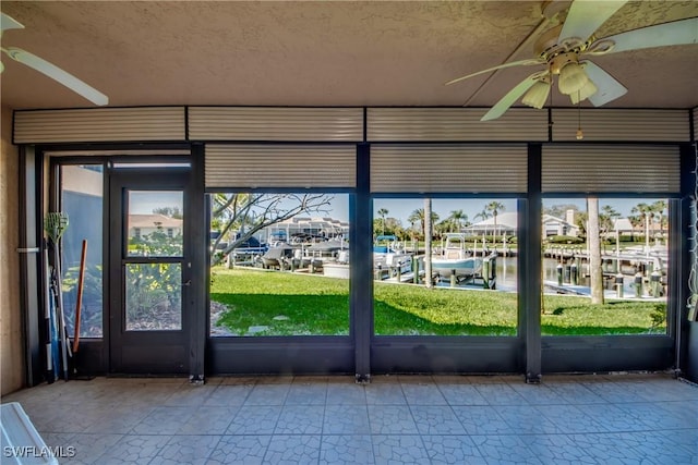 doorway with a ceiling fan, a water view, and a textured ceiling