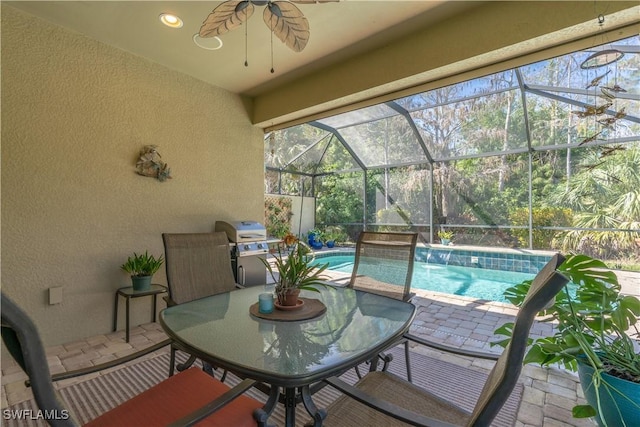 view of patio with glass enclosure, an outdoor pool, a ceiling fan, and area for grilling