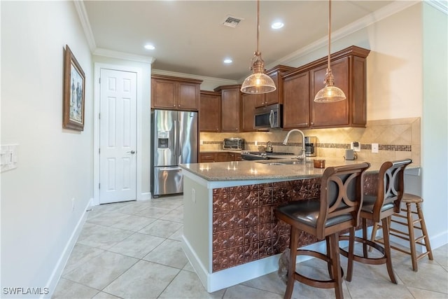 kitchen with visible vents, appliances with stainless steel finishes, a kitchen breakfast bar, a peninsula, and pendant lighting