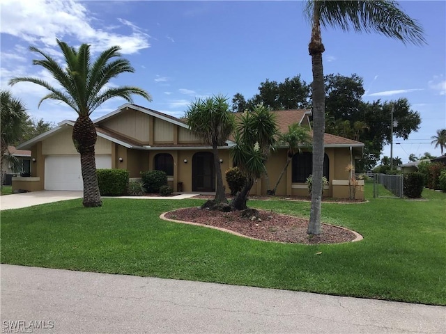 ranch-style home with driveway, a front yard, stucco siding, and a garage