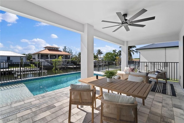 view of pool with a water view, ceiling fan, and a patio area