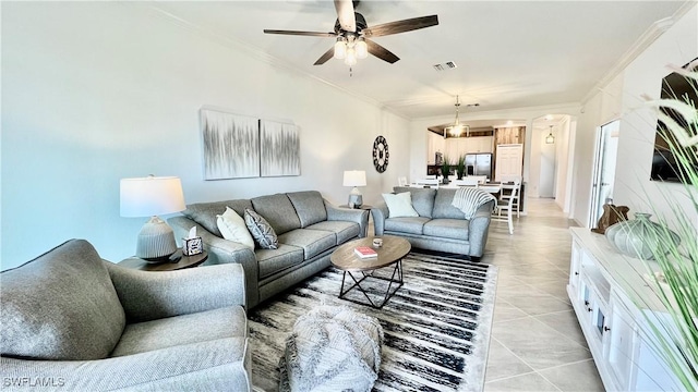 tiled living room featuring ceiling fan and crown molding