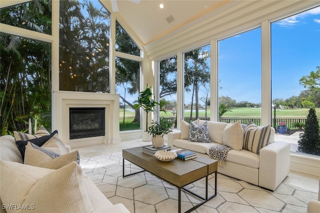 sunroom featuring lofted ceiling and a glass covered fireplace