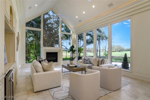 interior space with a ceiling fan, a glass covered fireplace, and vaulted ceiling