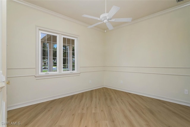 empty room with visible vents, ornamental molding, ceiling fan, light wood-type flooring, and baseboards