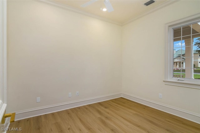 empty room with baseboards, visible vents, a ceiling fan, light wood-style flooring, and crown molding