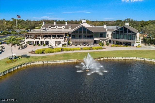 back of property featuring a water view and a yard