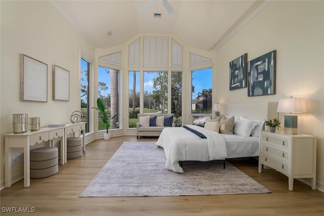 bedroom featuring crown molding, high vaulted ceiling, visible vents, and light wood-style floors