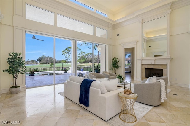 living area featuring a fireplace, a towering ceiling, and baseboards