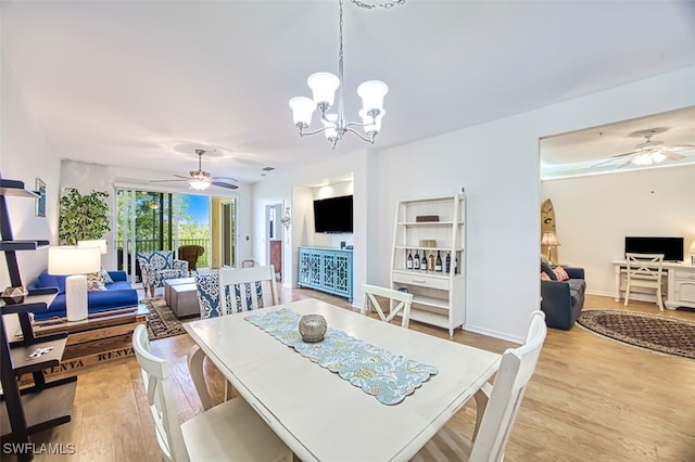 dining area with baseboards, light wood finished floors, and ceiling fan with notable chandelier