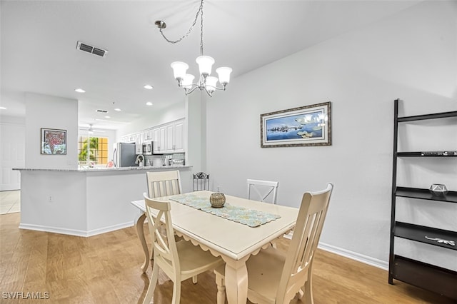 dining space with light wood-style floors, recessed lighting, visible vents, and a notable chandelier