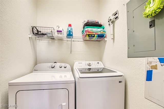 washroom with laundry area, electric panel, a textured wall, and independent washer and dryer