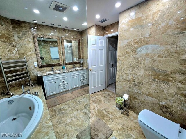 142 SE 30th Ter, Cape Coral, FL 33904 - bathroom with tile walls, toilet, a tub with jets, double vanity, and recessed lighting