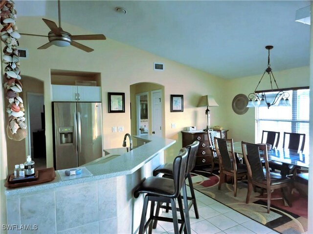 142 SE 30th Ter, Cape Coral, FL 33904 - kitchen featuring stainless steel fridge, vaulted ceiling, ceiling fan, light tile patterned floors, and hanging light fixtures