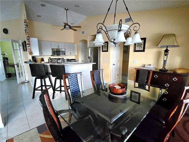 142 SE 30th Ter, Cape Coral, FL 33904 - dining room featuring a ceiling fan, lofted ceiling, light tile patterned flooring, and arched walkways