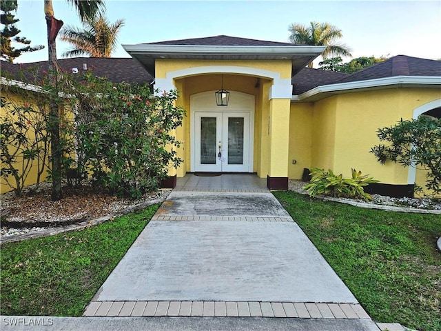 142 SE 30th Ter, Cape Coral, FL 33904 - doorway to property featuring french doors, stucco siding, and a shingled roof