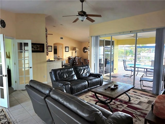 142 SE 30th Ter, Cape Coral, FL 33904 - living room featuring a ceiling fan, arched walkways, vaulted ceiling, and light tile patterned floors