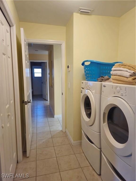 142 SE 30th Ter, Cape Coral, FL 33904 - laundry area featuring light tile patterned floors, washer and dryer, and baseboards