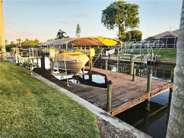 142 SE 30th Ter, Cape Coral, FL 33904 - dock featuring boat lift, a water view, and a yard