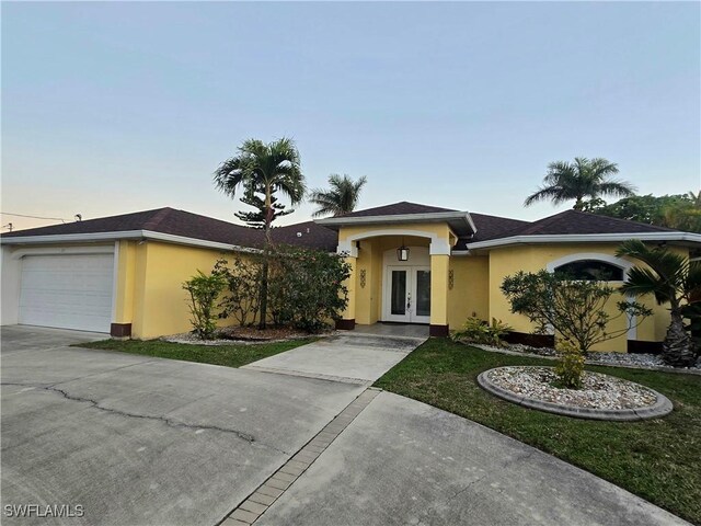 142 SE 30th Ter, Cape Coral, FL 33904 - single story home with french doors, stucco siding, concrete driveway, and a garage