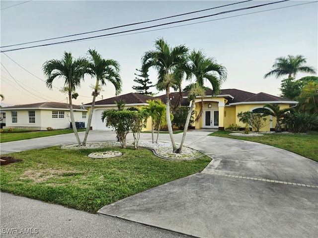 142 SE 30th Ter, Cape Coral, FL 33904 - ranch-style house featuring french doors, curved driveway, a front lawn, and stucco siding