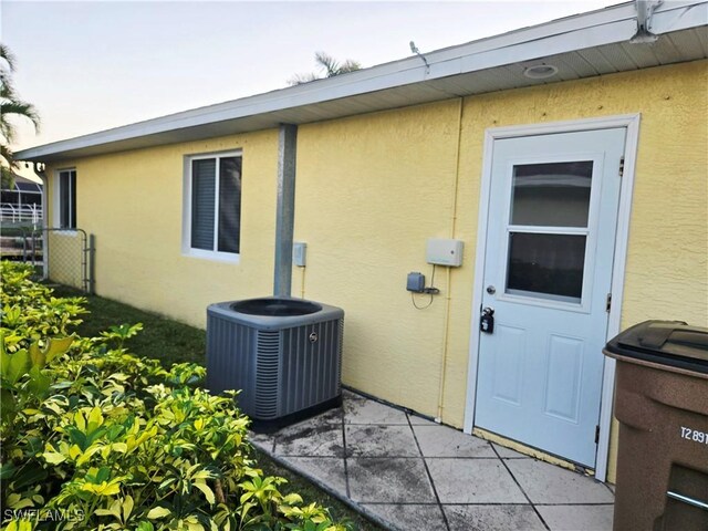 142 SE 30th Ter, Cape Coral, FL 33904 - entrance to property featuring central AC, stucco siding, and fence