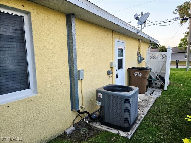 142 SE 30th Ter, Cape Coral, FL 33904 - exterior view of cooling unit, stucco siding, a satellite dish, and fence