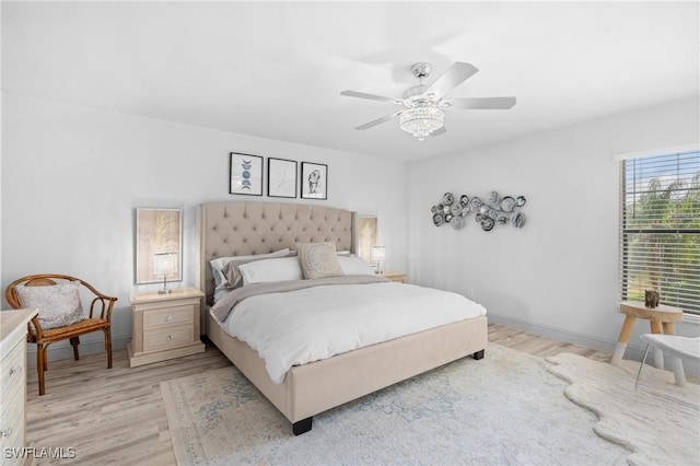 bedroom featuring light wood-style floors, baseboards, and a ceiling fan