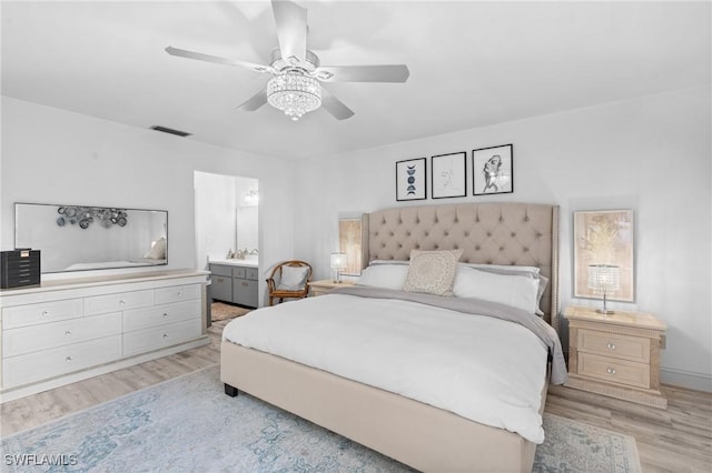 bedroom featuring visible vents, light wood-style flooring, connected bathroom, ceiling fan, and a sink