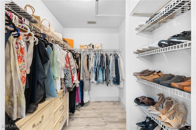 spacious closet with light wood-style floors, attic access, and visible vents