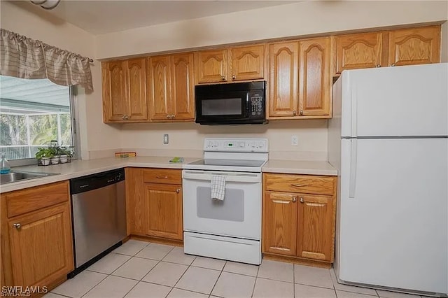 kitchen with sink, white appliances, and light tile patterned floors