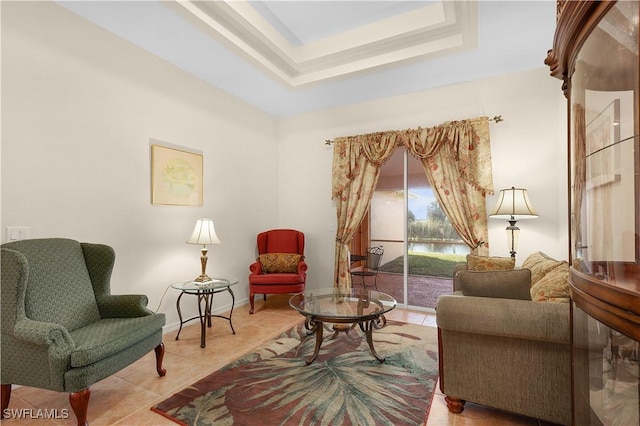 sitting room with light tile patterned floors and a raised ceiling