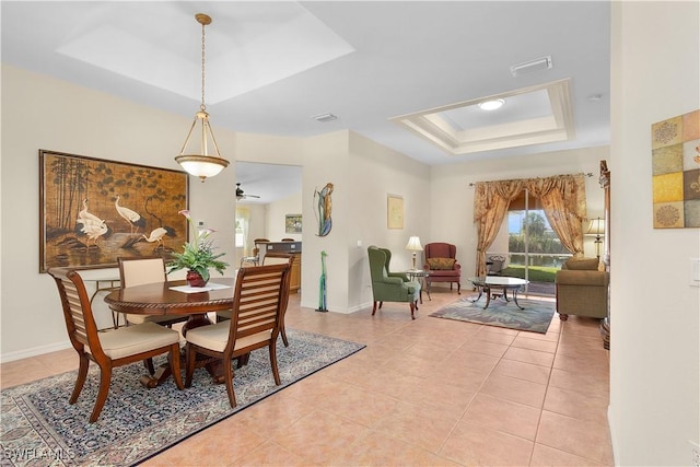 tiled dining space with a tray ceiling