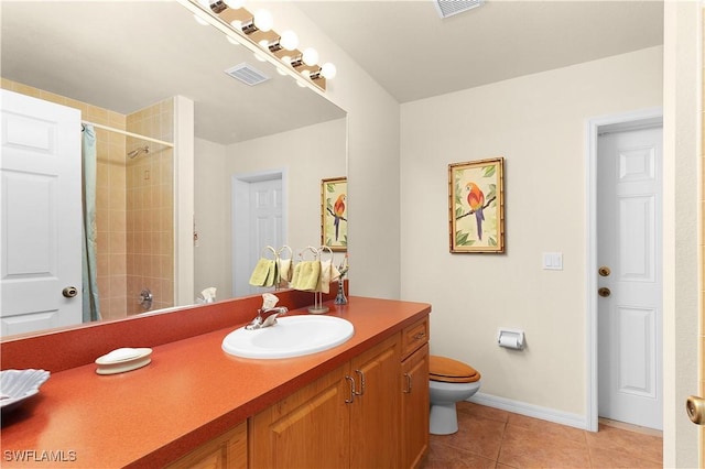 bathroom featuring tile patterned flooring, vanity, toilet, and tiled shower