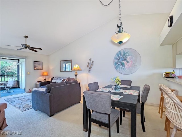 carpeted dining room featuring vaulted ceiling and ceiling fan