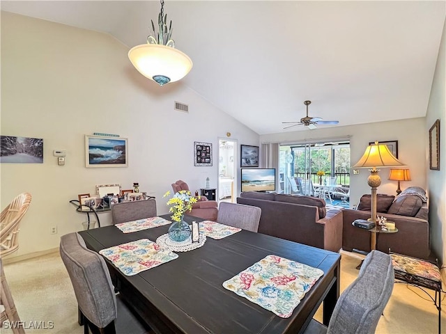 carpeted dining space with ceiling fan and high vaulted ceiling