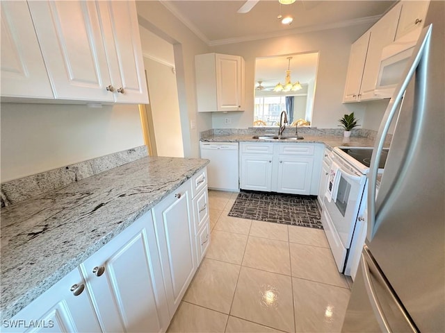 kitchen featuring hanging light fixtures, white appliances, white cabinetry, and a sink