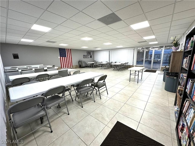 dining area featuring light tile patterned flooring and a drop ceiling