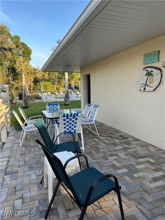 view of patio featuring outdoor dining space and fence