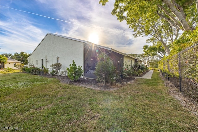 view of side of home with a yard