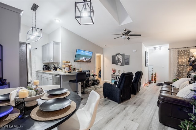 dining room featuring ceiling fan, light hardwood / wood-style flooring, and vaulted ceiling