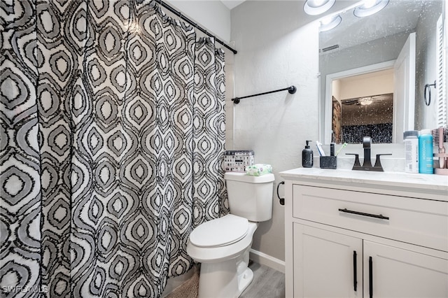 bathroom with hardwood / wood-style flooring, toilet, and vanity