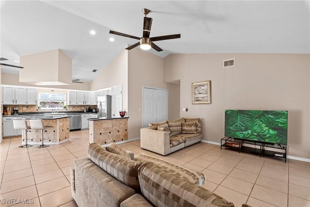 living room featuring light tile patterned floors, ceiling fan, high vaulted ceiling, visible vents, and baseboards