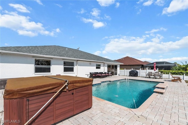 view of swimming pool with a hot tub, fence, a fenced in pool, and a patio