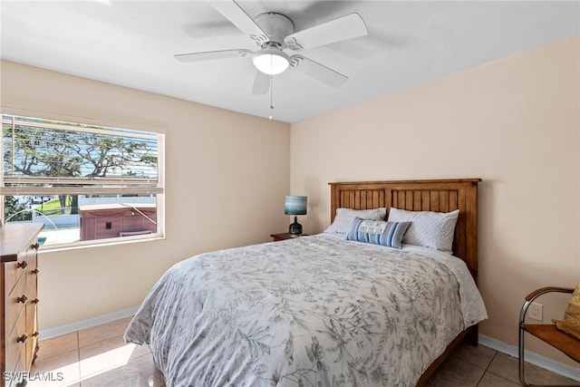 bedroom with baseboards, a ceiling fan, and light tile patterned flooring