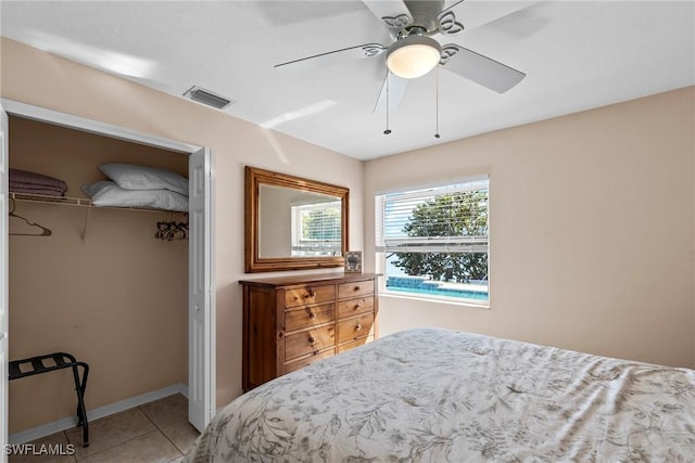 bedroom with ceiling fan, visible vents, baseboards, a closet, and tile patterned floors